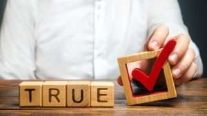 man holding checkmark next to the words true